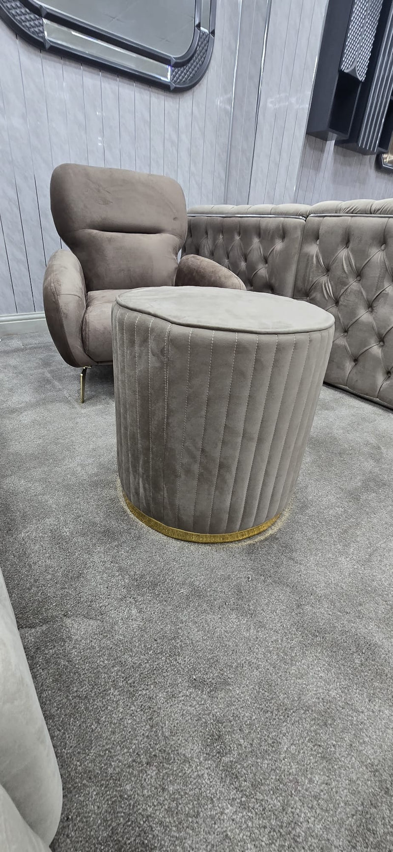 Beige upholstered chair and ottoman in a room with a mirror on the wall.
